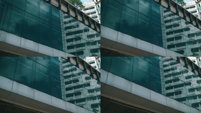 一个亚洲人站在窗前，思考着自己在大楼里所承受的压力