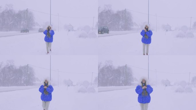 一名身穿蓝色外套的女子欣赏真正的冬季童话，她走在斯堪的纳维亚村庄的街上，大雪纷天