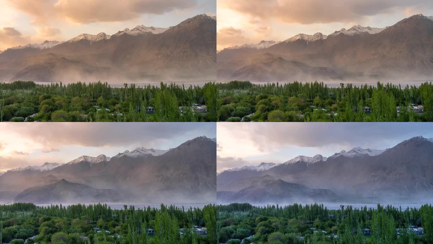 在巴基斯坦北部斯卡都的喀喇昆仑山脉，寒冷的沙漠，周围有雪帽山，移动的云和灰尘吹过沙丘