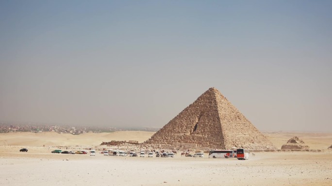 许多旅游巴士停在吉萨的门卡拉金字塔附近。开罗,埃及。古代神秘的世界奇观