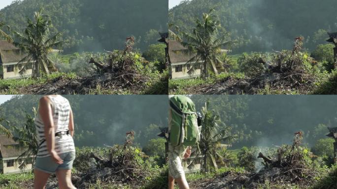 焚烧垃圾冒烟的热带村庄，人们走过，慢镜头