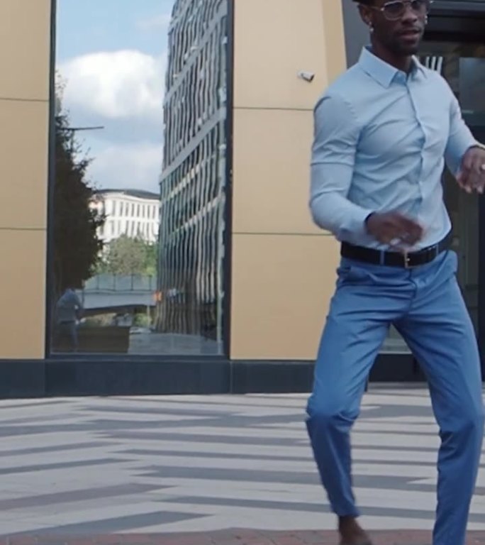 一个非裔美国人在城市街道上跳舞。帅气的黑人男模特在户外