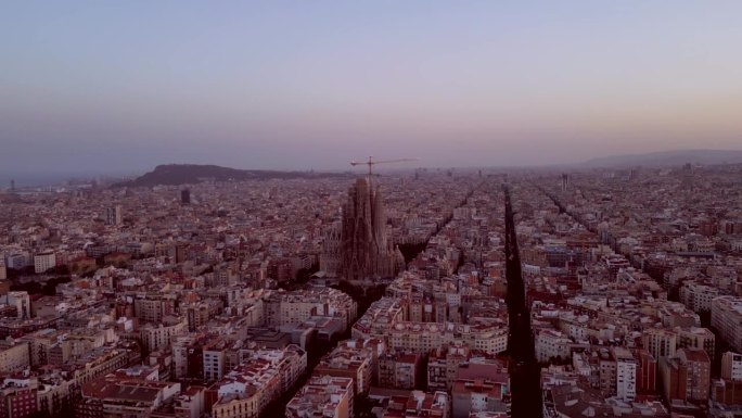 电影般的圣家堂和巴塞罗那城市天际线的空中无人机。