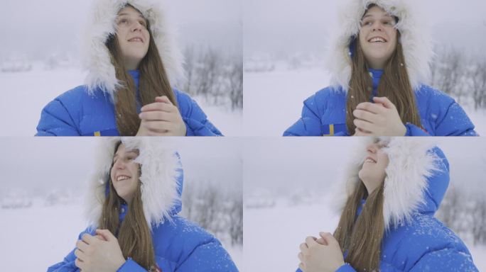 在大雪中漫步在斯堪的纳维亚村庄的蓝大衣女人正在思考真正的冬季童话