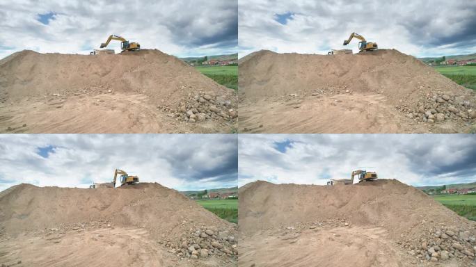 工业挖掘机将公路施工现场的土料装入自卸车