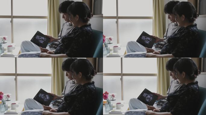 年轻的怀孕夫妇正在看婴儿超声录像