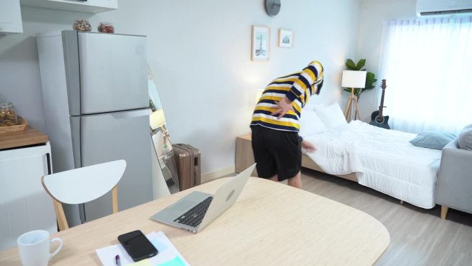 亚洲商人使用笔记本电脑患有腰痛和躺在床上缓解疼痛在家工作的症状办公室综合症。