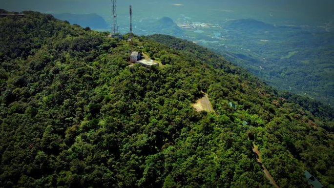 泰国一个森林覆盖的高山高峰的高角度照片。有一个传送电话信号的塔