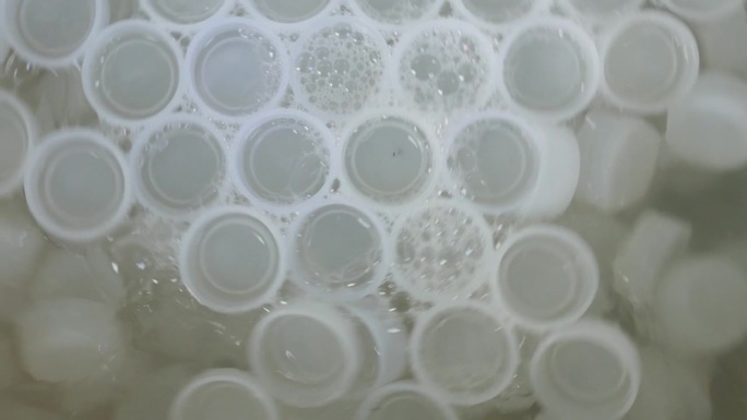 白色空塑料瓶盖瓶手动旋流机清洗干净塑料瓶盖厂。环境废物和回收概念，4k，抽象