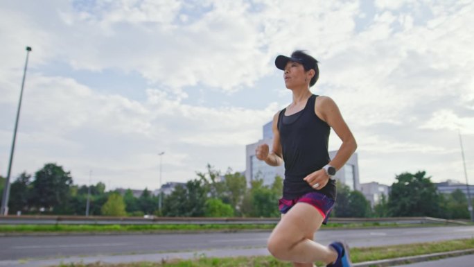 SLO MO TS运动亚洲女子在城市跑步
