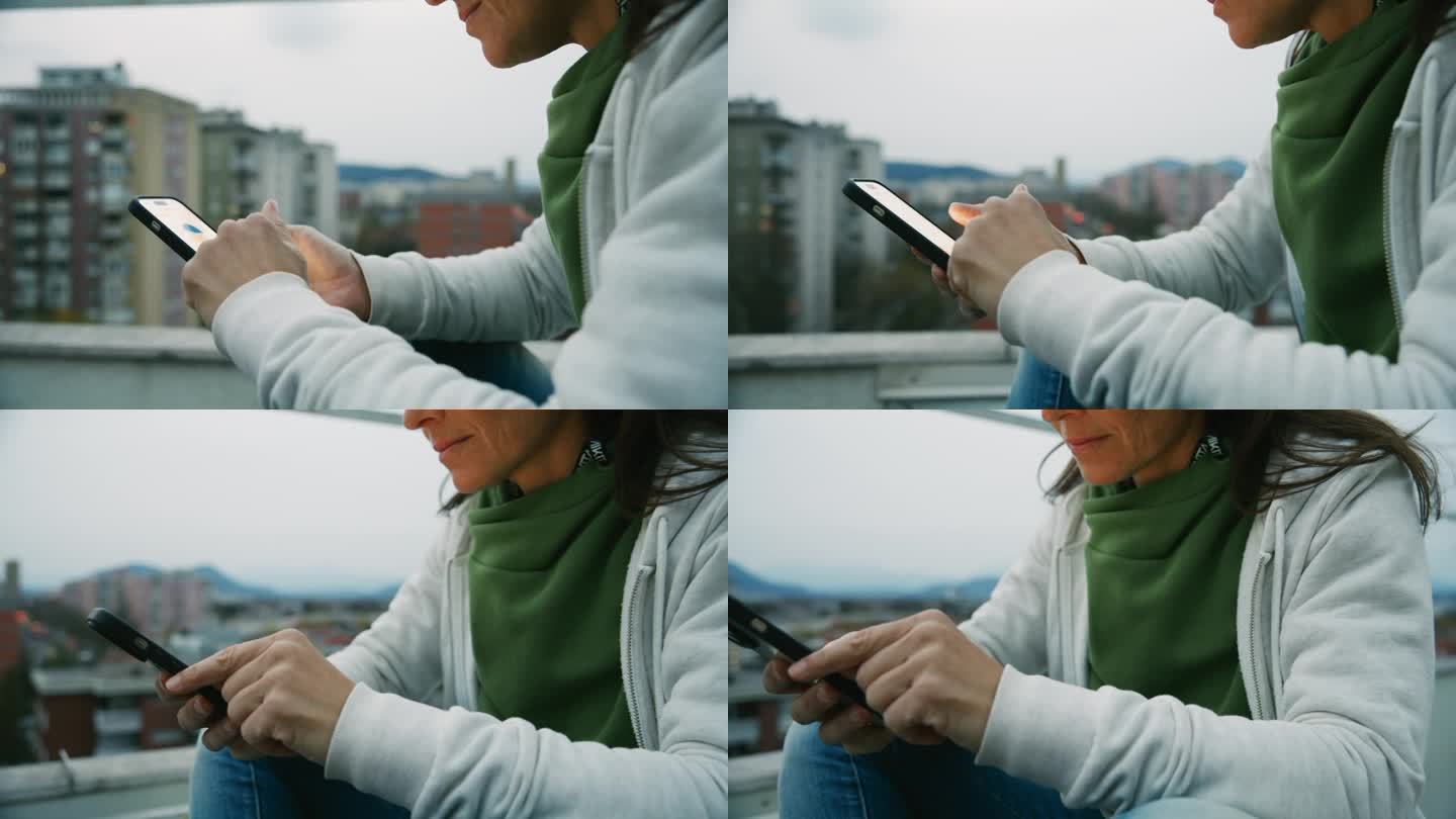 近距离拍摄在城市屋顶上使用智能手机的女人