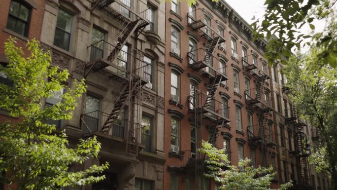 在纽约市翻新砖多层公寓大楼。老褐石屋。有紧急楼梯和空调的房子白天的城市景观