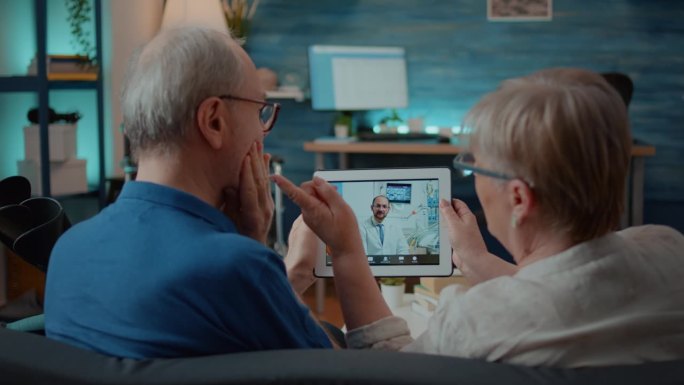 一名老年男子和一名老年妇女正在与牙医进行在线视频通话