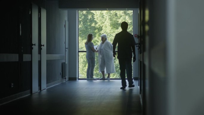 医务人员和病人在黑暗的医院或医疗中心走廊