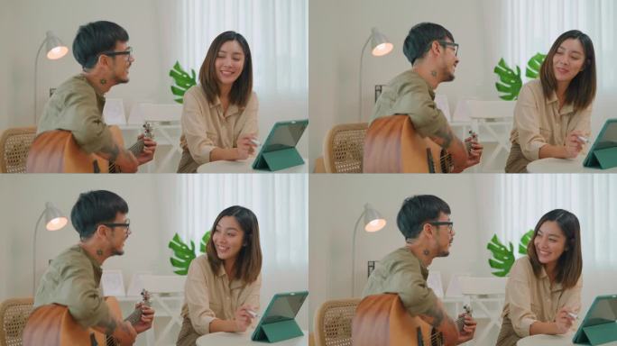 一对亚洲夫妇在家里弹吉他休息