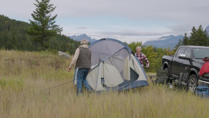 成熟的夫妇在草地上搭起帐篷