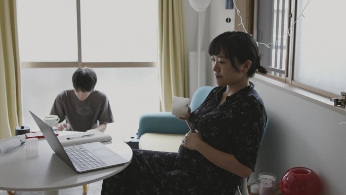 年轻的日本孕妇在家工作