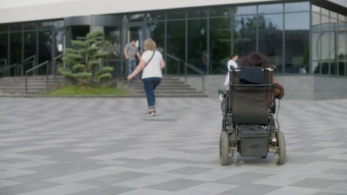 一名残疾妇女乘坐机动轮椅前往诊所