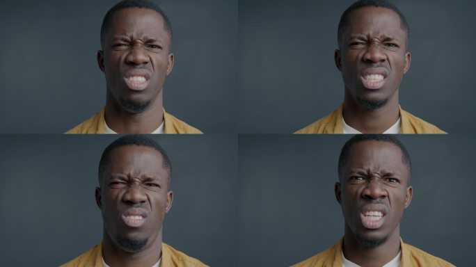 愤怒的非裔美国人的特写慢动作肖像，他露出愤怒的牙齿，看着镜头