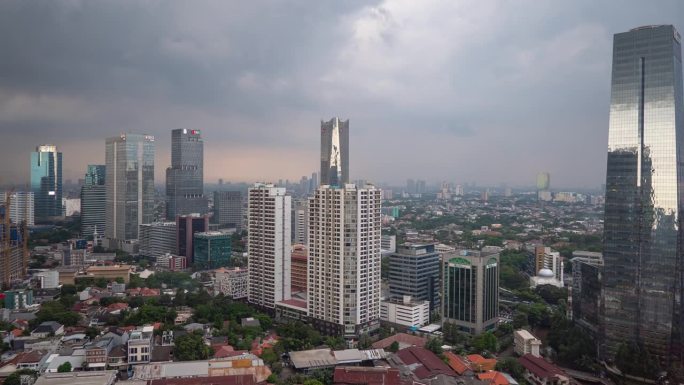 日落风暴天空雅加达市中心屋顶全景4k延时拍摄印度尼西亚
