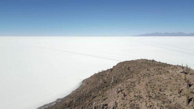 玻利维亚乌尤尼盐湖棕色山脉的俯视图，航拍轨道