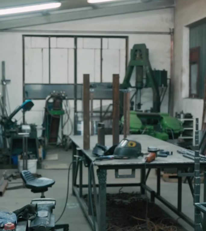 制造工厂焊接头盔附近的金属框架和工作台上的工具-垂直