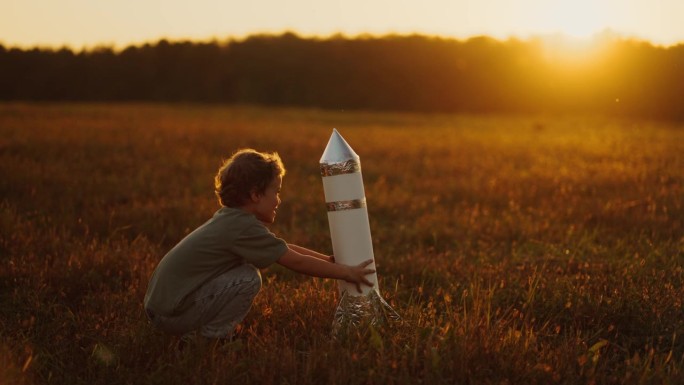 暑假男孩在田野里玩玩具火箭，周末孩子在乡下度过