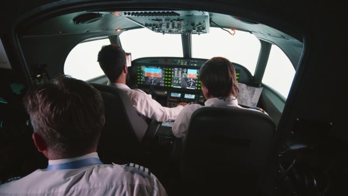 在飞行过程中，教官和飞行员在专业的飞行模拟器中