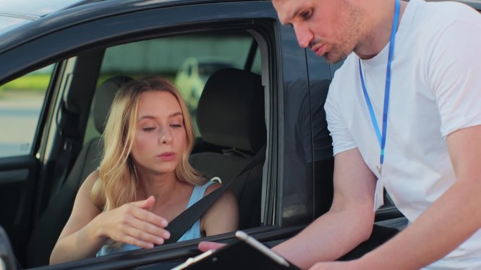 一个拿着写字板的男子驾驶学校教师和一个女司机在车里。教育、考试和人的观念。
