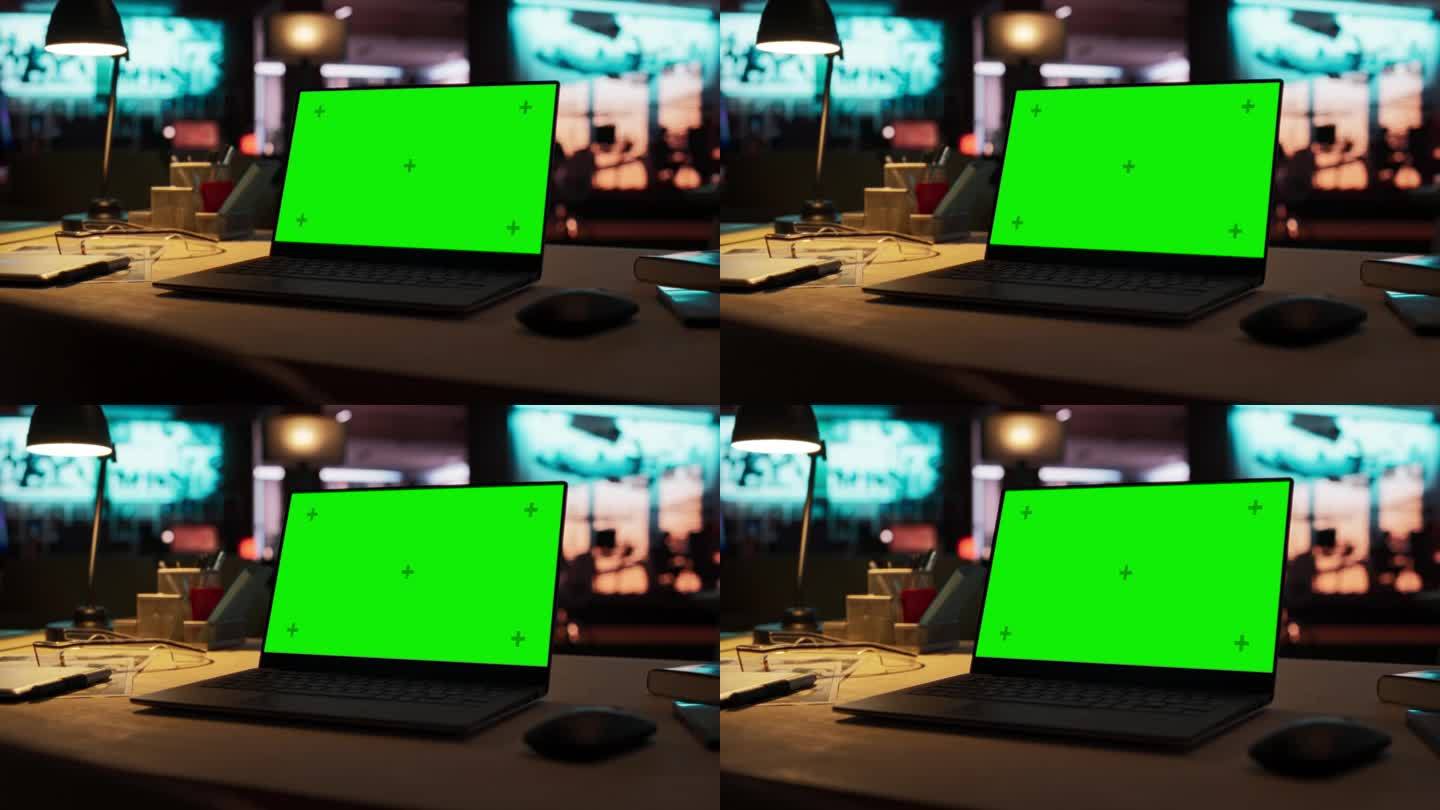 放大笔记本电脑绿屏模型站在木桌上。在背景时尚的现代办公室工作室在霓虹灯的晚上。创意设计师办公桌