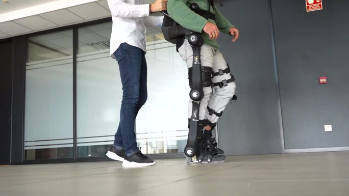 机械外骨骼，物理治疗师带着机器人骨骼行走，现代医院的物理治疗: