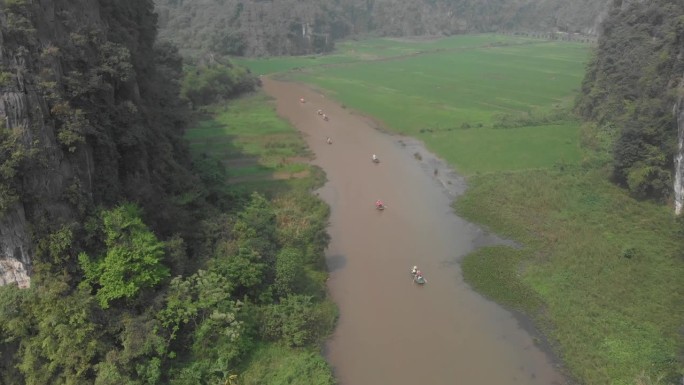飞越越南宁平的河流，周围环绕着绿色的稻田