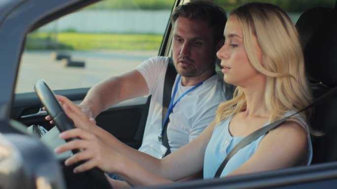年轻女子和驾校教练拿着写字板在车里聊天。女子在车里听教练学开车。