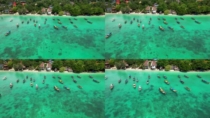 泰国长尾船停泊在海滩上美丽的蓝色热带水域-空中飞进来