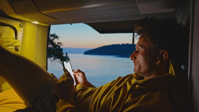 男子在露营车上用智能手机上网
