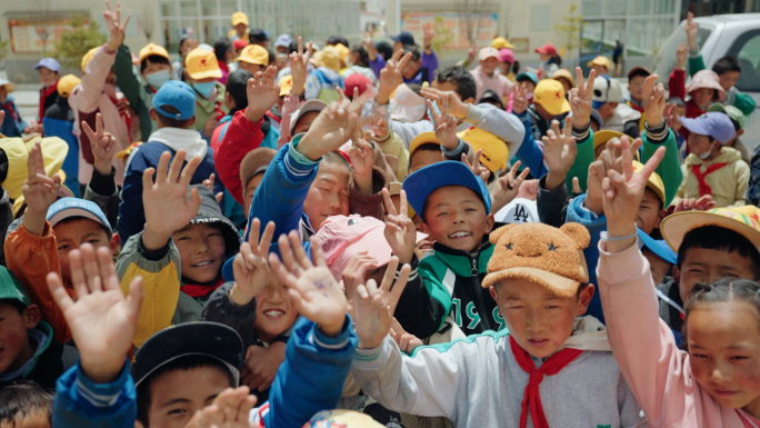 一群藏族小学生对着镜头招手