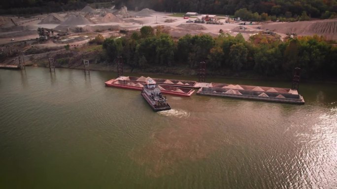 无人机拍摄的一艘大型沙船在日落时停靠在俄亥俄河岸边的沙矿旁