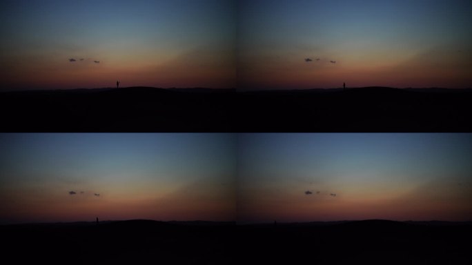 日暮时分行走在沙漠里的人