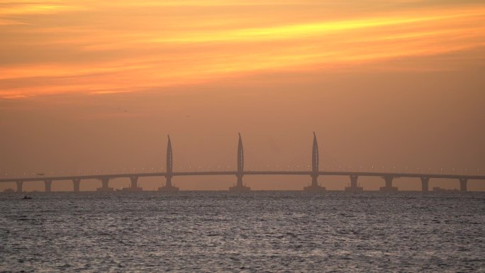 海鸥飞过朝霞中的港珠澳大桥海豚塔