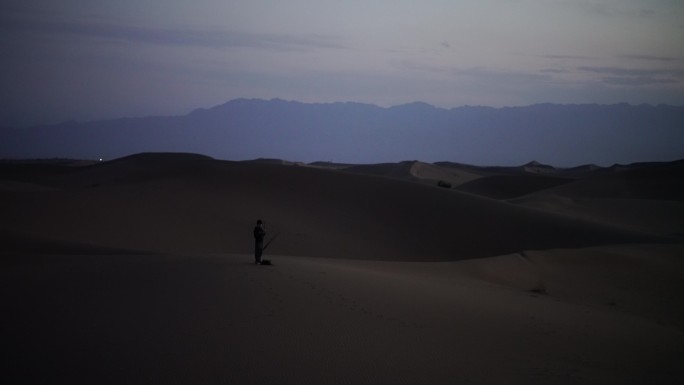 日暮时分行走在沙漠里的人