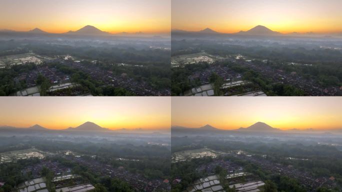 空中无人机拍摄的印尼巴厘岛丛林中，以阿贡火山为背景的高山梯田的日出景象。