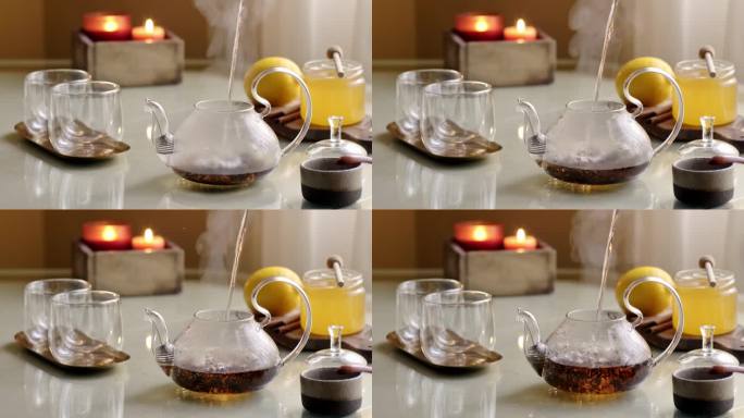 将热气腾腾的热水倒入煮红茶的透明壶中。