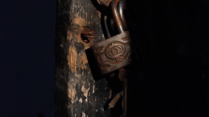 光影下的古老的木板门和锁