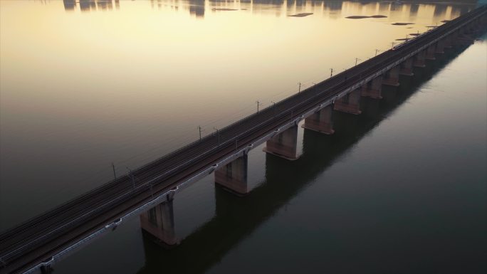 黎明日出前的高铁行驶在跨江大桥上