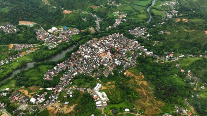 在多云的哥伦比亚，高空无人机拍摄的环绕圣拉斐尔村的照片