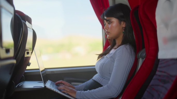女乘客在公交车上使用笔记本电脑