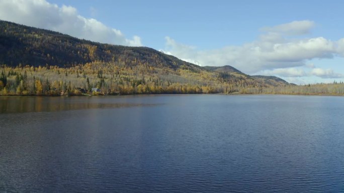 靠近水面缓缓上升的移动无人机拍摄的西摩湖在史密瑟斯，北不列颠哥伦比亚省(BC)地区在秋天的几个月。