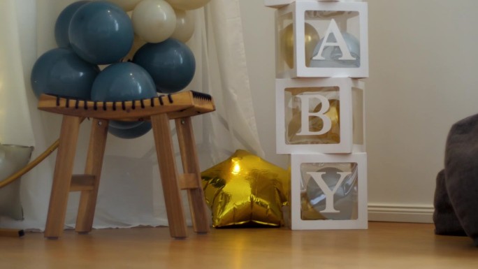 白色立方体拼写婴儿包含气球装饰。