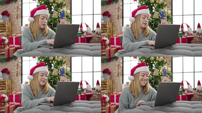 年轻的金发女人买笔记本电脑和信用卡在家里庆祝圣诞节