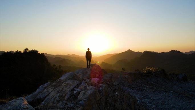 一个男人站在山顶眺望远方成功人士企业家